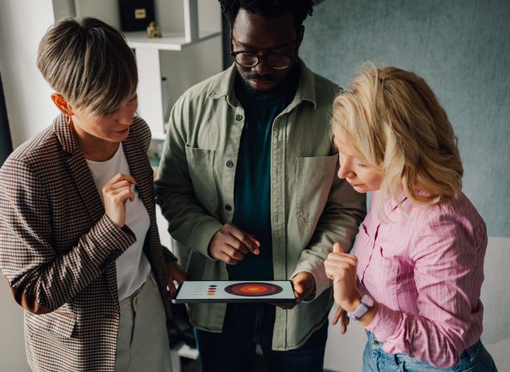 Marketing team analyzing data on a tablet in the office